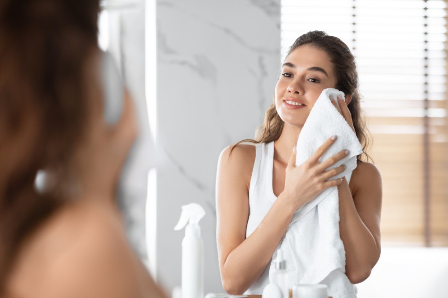 Lau khô mặt với khăn mềm hoặc bông tẩy trang